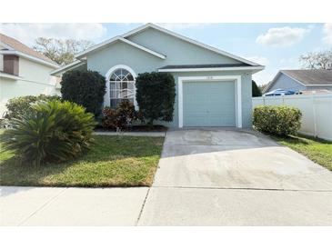 Charming single-story home with manicured lawn, complemented by a matching two-car garage and a classic arched window at 1318 Daniels Cove Dr, Winter Garden, FL 34787