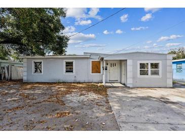 Modest single-story home featuring a light-colored exterior and a small front yard at 1408 N Pine Hills Rd, Orlando, FL 32808