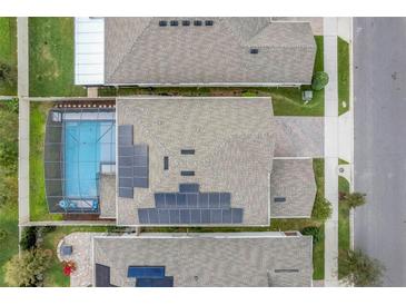 Aerial view of a home showing the roof with solar panels and a screened pool at 1472 Rushing Rapids Way, Winter Springs, FL 32708