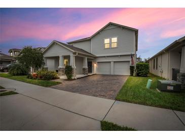 Charming two-story home featuring a well-manicured lawn and a welcoming front porch with stone detailing at 1472 Rushing Rapids Way, Winter Springs, FL 32708