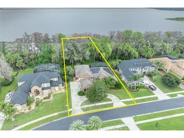 Stunning lakefront property boasts lush landscaping, mature trees, and a private backyard oasis at 210 Torcaso Ct, Winter Springs, FL 32708