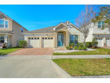 Charming one-story home featuring a three-car garage, stone accents, and a brick-paved driveway at 5023 Southlawn Ave, Orlando, FL 32811