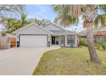 Charming single-story home featuring a well-maintained lawn, two-car garage, and inviting front entrance at 116 Douglas St, Edgewater, FL 32141