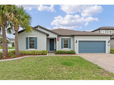 Charming single-story home featuring a well-manicured lawn, palm tree and inviting blue accents at 1380 Patterson Ter, Lake Mary, FL 32746