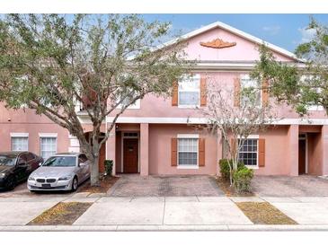 Charming two-story townhome with a brick driveway and landscaped yard, creating a welcoming curb appeal at 2328 Caravelle Cir, Kissimmee, FL 34746