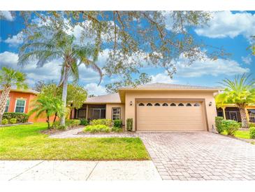 Charming one-story home featuring a manicured lawn, brick driveway, and a two-car garage at 321 Davinci Pass, Kissimmee, FL 34759