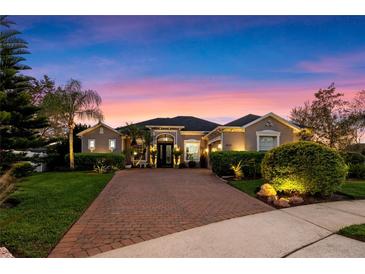 Beautiful single-story home featuring a large brick driveway and meticulously manicured landscaping at 3930 Hydrangea Ct, Oviedo, FL 32766
