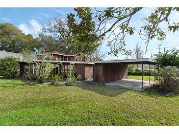 Charming two-story home with mature trees, manicured lawn, and convenient covered carport at 425 S Woodland St, Winter Garden, FL 34787