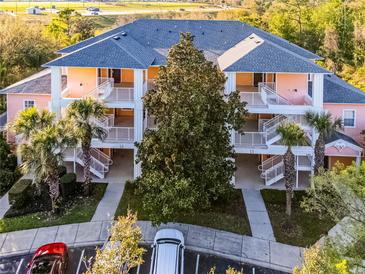 Attractive condo community with multiple units, white railings, and lush landscaping at 506 New Providence Promenade # 506, Davenport, FL 33897