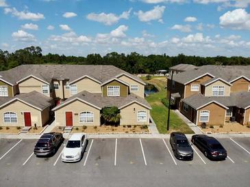 A sunny view of the apartment complex shows ample parking and well-maintained landscaping at 601 Washington Palm Loop, Davenport, FL 33897