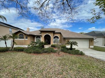 Beautiful single story home with desert landscaping, arched windows, and an attached two car garage at 7741 Bardmoor Hill Cir, Orlando, FL 32835