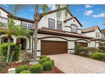 Beautiful multi-story home with a well-manicured lawn, lush landscaping, and an attached two-car garage at 8209 Tivoli Dr, Orlando, FL 32836