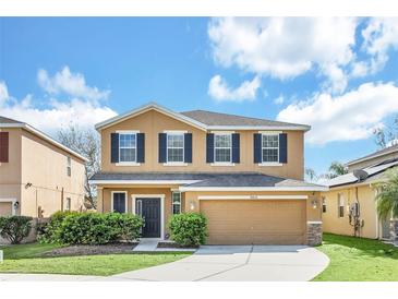 Inviting two-story home featuring a well-maintained lawn and a neutral color palette at 14806 Del Morrow Way, Orlando, FL 32824