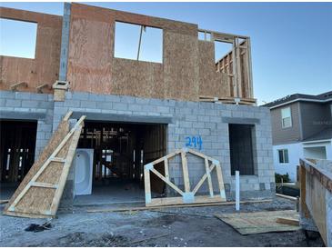 New construction of a two-story home featuring concrete blocks and wood framing, showcasing a work-in-progress residential structure at 14906 Harvest St, Orlando, FL 32824