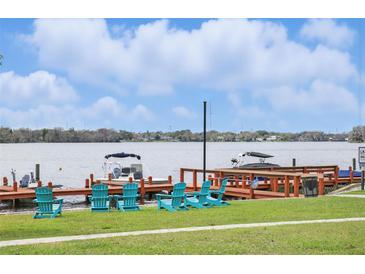 Scenic waterfront view with chairs on the lawn and boats docked at the private pier at 151 N Orlando Ave # 229, Winter Park, FL 32789