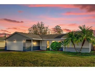 Charming single-story home featuring well-maintained landscaping, palm trees, and a two-car garage at 1585 Randolph St, Deltona, FL 32725