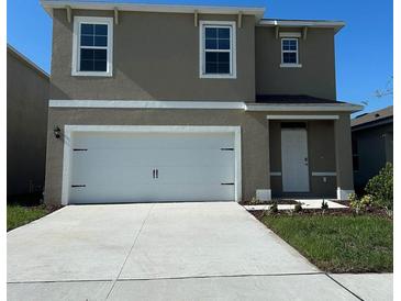 Charming two-story home with a pristine white garage door and a well-maintained lawn at 3017 Moulin Rd, Davenport, FL 33837