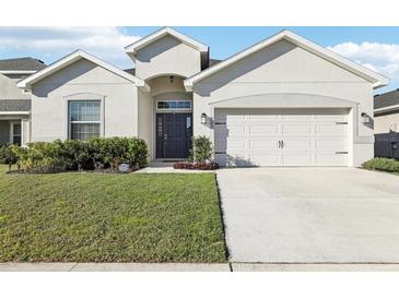Attractive single-story home with a well-manicured lawn and inviting front facade at 411 Lily Ln, Davenport, FL 33837