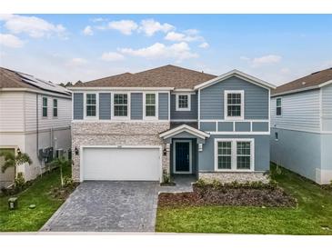 Charming two-story home boasts a beautiful stone facade, manicured lawn and covered entryway at 4149 Lana Ave, Davenport, FL 33897