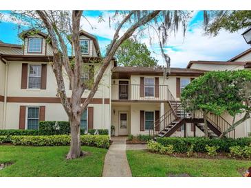 Inviting townhome featuring charming exterior details, lush landscaping, and stairway to the second floor at 600 Northern Way # 404, Winter Springs, FL 32708