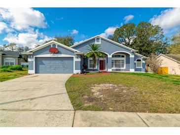 Charming one-story home with blue exterior, attached garage, landscaped yard, and a basketball hoop at 6018 Long Peak Dr, Orlando, FL 32810