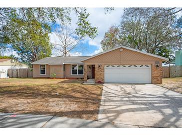 Charming single-story home with a well-manicured lawn, attached garage, and inviting facade at 7730 Pineapple Dr, Orlando, FL 32835