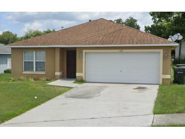 Cozy single-story home featuring a one-car garage and a well-maintained front yard with verdant grass at 142 Parker Cove Ct, Ocoee, FL 34761