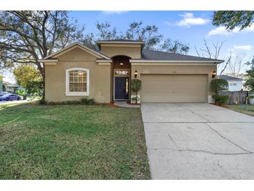 Charming single-story home with tan stucco, arched entryway, two-car garage, and well-maintained lawn at 2700 Child St, Ocoee, FL 34761