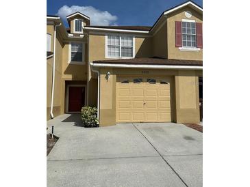 Charming townhome showcasing a two-car garage, light-colored exterior, and a welcoming front door at 2952 Ashland S Ln, Kissimmee, FL 34741