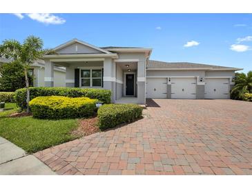 Charming single-Gathering home with a three-car garage, landscaped yard, and beautiful brick driveway at 3136 Winesap Way, Winter Garden, FL 34787