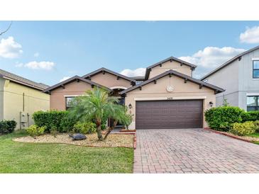 Charming single-Gathering home featuring a paver driveway, two-car garage and well-manicured landscaping at 3430 Halsway Dr, Orlando, FL 32824