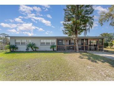 Charming single-story home with a screened-in porch, green lawn, and mature trees at 395 Bearcreek Dr, Bartow, FL 33830