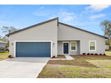 Modern one-story home showcasing a blue garage door and complementary blue front door at 4016 Sw 151 Street, Ocala, FL 34473