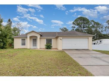 Charming single-story home featuring a two-car garage and well-maintained front lawn under a bright sky at 760 Mentmore Cir, Deltona, FL 32738