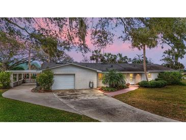 Charming single-story home with brick exterior, mature landscaping, and a spacious driveway at 803 N Shore Dr, Leesburg, FL 34748