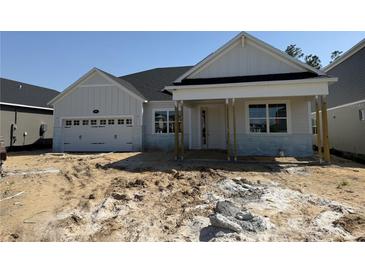Charming single-story home featuring a two-car garage, craftsman architecture, and covered porch at 804 Pointe Emerson Blvd, Apopka, FL 32703