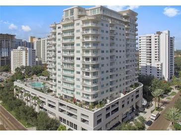 Luxury condominium with multiple balconies, a rooftop pool, parking, and mature landscaping at 100 S Eola Dr # 1211, Orlando, FL 32801