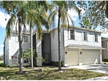 Two-story home with an attached two-car garage, pale blue paint, white trim, and lush palm trees at 1215 Castleport Rd, Winter Garden, FL 34787