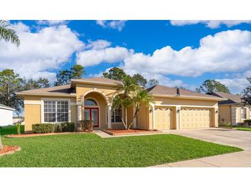 Charming one-story home featuring a three-car garage, lush lawn, and vibrant red front door, beneath a bright, cloudy sky at 2582 Greenwillow Dr, Orlando, FL 32825