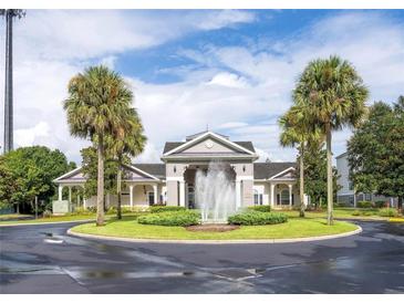 Elegant community entrance featuring a decorative fountain, manicured landscaping, and classic architectural design at 3175 Feltrim Pl # 304, Kissimmee, FL 34747