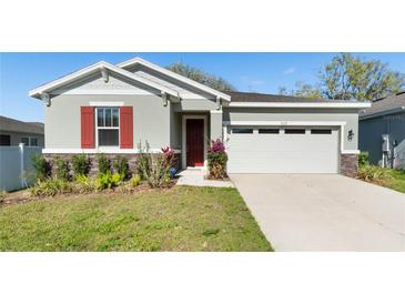 Charming single-Gathering home featuring a well-maintained lawn and a two-car garage at 5315 Meadow Song Dr, Okahumpka, FL 34762