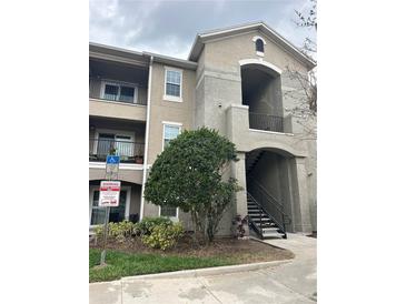 Two-story residential apartment building exterior with private balconies and landscaped yard at 6596 Swissco Dr # 15, Orlando, FL 32822