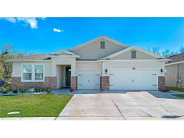 Charming single-Gathering home featuring a well-manicured lawn, two-car garage, and beautiful stone accents at 1636 Barberry Dr, Kissimmee, FL 34744