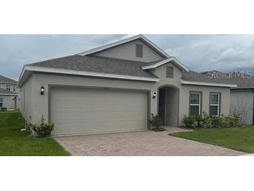 Inviting single-story home with a neutral paint, attached two-car garage, and tidy landscaping at 4210 Deleon St, Haines City, FL 33844