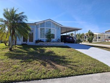 Charming home with a carport and well-maintained lawn and a palm tree in a desirable neighborhood at 50989 Highway 27 # 130, Davenport, FL 33897