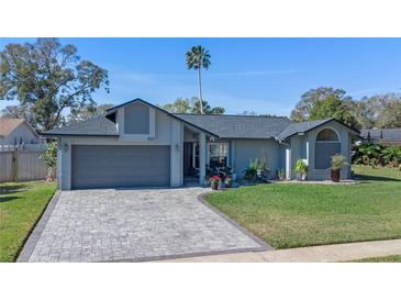 Charming home with a well-manicured lawn and paver driveway, showcasing curb appeal at 825 Rosemere Cir, Orlando, FL 32835