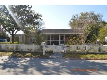Charming single-story home with a white picket fence and screened porch at 933 Lakehurst St, Lakeland, FL 33805
