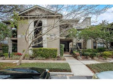 Exterior view of building showing multiple units, parking, and well-maintained landscaping at 1075 Kensington Park Dr # 203, Altamonte Springs, FL 32714