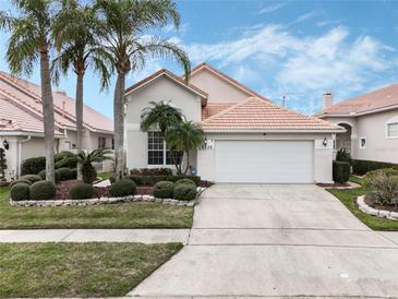 Charming single-Gathering home with a well-manicured lawn, a two-car garage and a beautiful red tile roof at 13336 Lake Turnberry Cir, Orlando, FL 32828