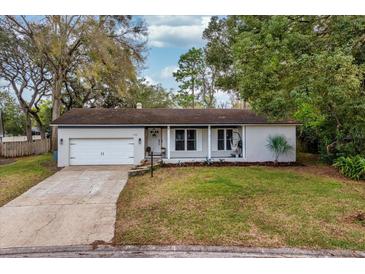 Charming single-story home with a well-manicured lawn and attached garage with a concrete driveway at 142 Habersham Dr, Longwood, FL 32779